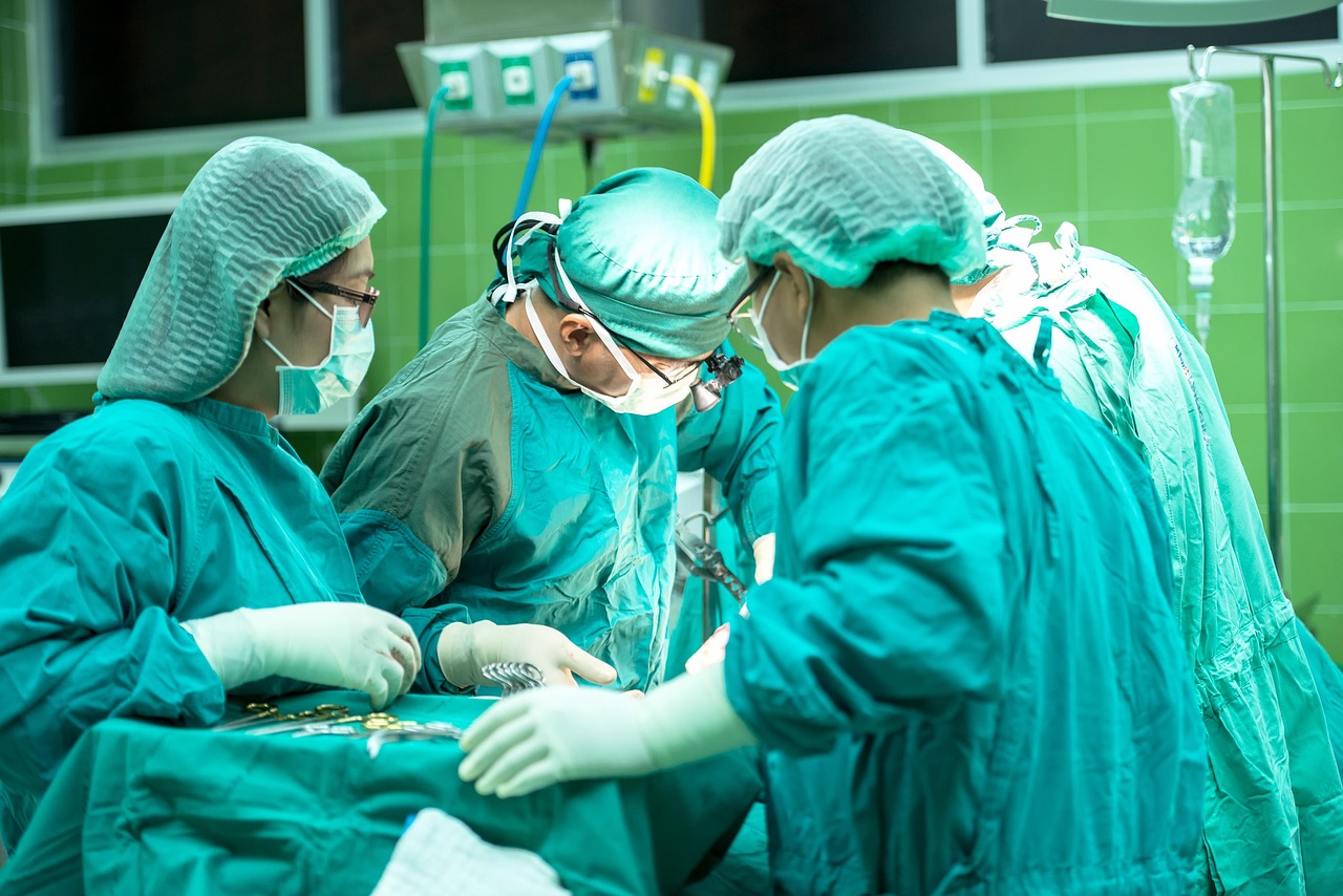 Surgical team performing a procedure in a modern operating room, representing healthcare organizations seeking Medical office financing, financing medical equipment, satellite clinic funding, occupational health clinic financing, and financing a new urgent care center to expand facilities, acquire advanced medical technology, and improve patient care services.