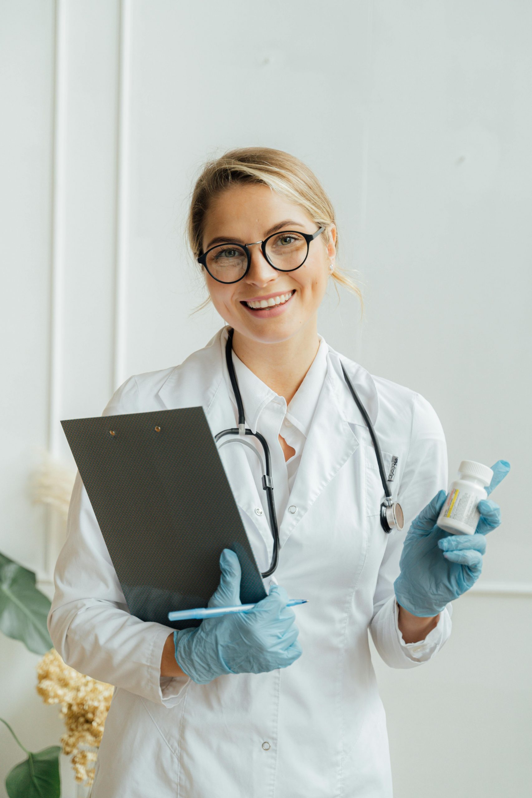 Female healthcare professional holding patient records and medication while representing healthcare organizations seeking physician line of credit, physician working capital loans, capital for expanding a medical office, community health center loans, and financing technology upgrades for clinics to support growth, patient care improvements, technology modernization, and daily operational funding.