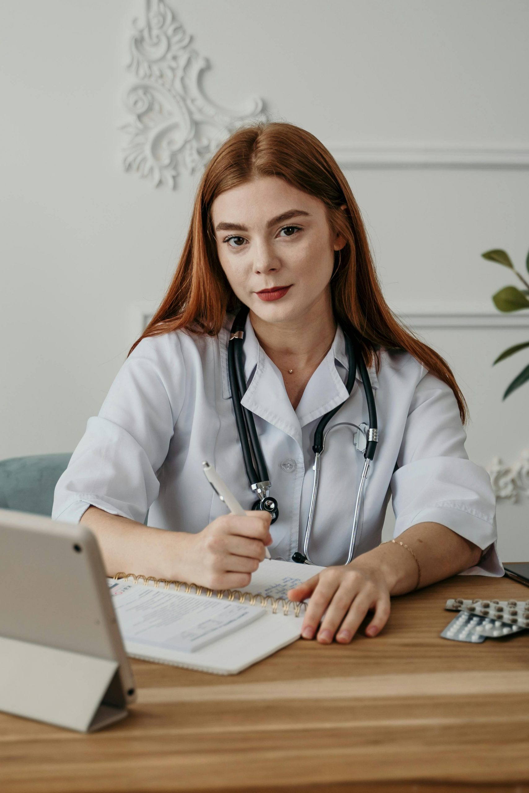 Female healthcare provider reviewing patient records and financial documents in a modern medical office, representing outpatient clinic financing, healthcare equipment financing, healthcare real estate financing, physician partnership buy-in financing, and physician practice acquisition loans used to support healthcare practice growth, facility expansion, equipment purchases, and ownership transitions.