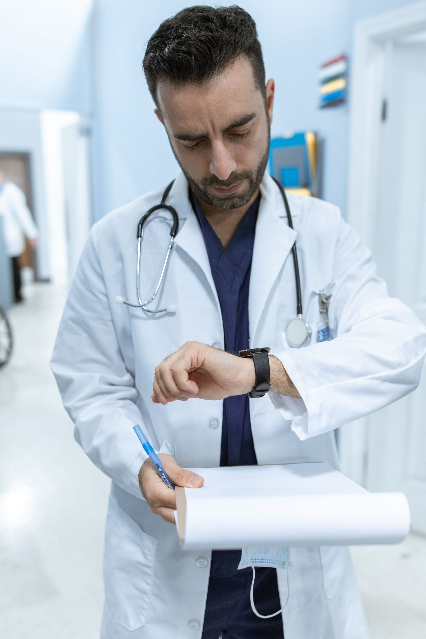Healthcare professional reviewing patient records and treatment schedules in a hospital corridor, representing clinic financing specialists, patient monitoring equipment lease, hospital wing expansion funding, and children's hospital financing used to support healthcare operations, pediatric care expansion, medical equipment acquisition, and facility growth.