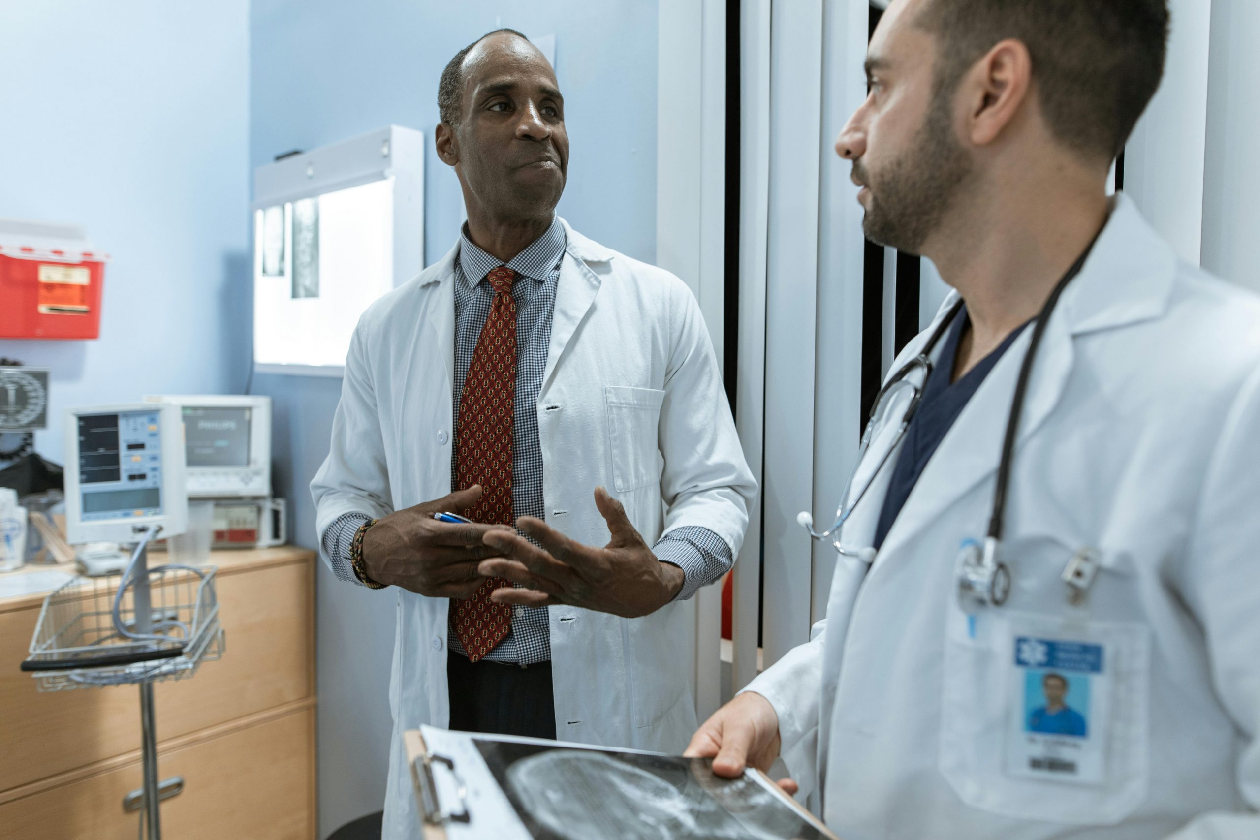 Two physicians discussing patient care and reviewing medical imaging inside a modern healthcare facility, representing healthcare lending solutions, healthcare revenue cycle financing, physician receivables funding, outpatient surgery center funding, and healthcare infrastructure financing used to support technology upgrades, facility expansion, and operational growth.