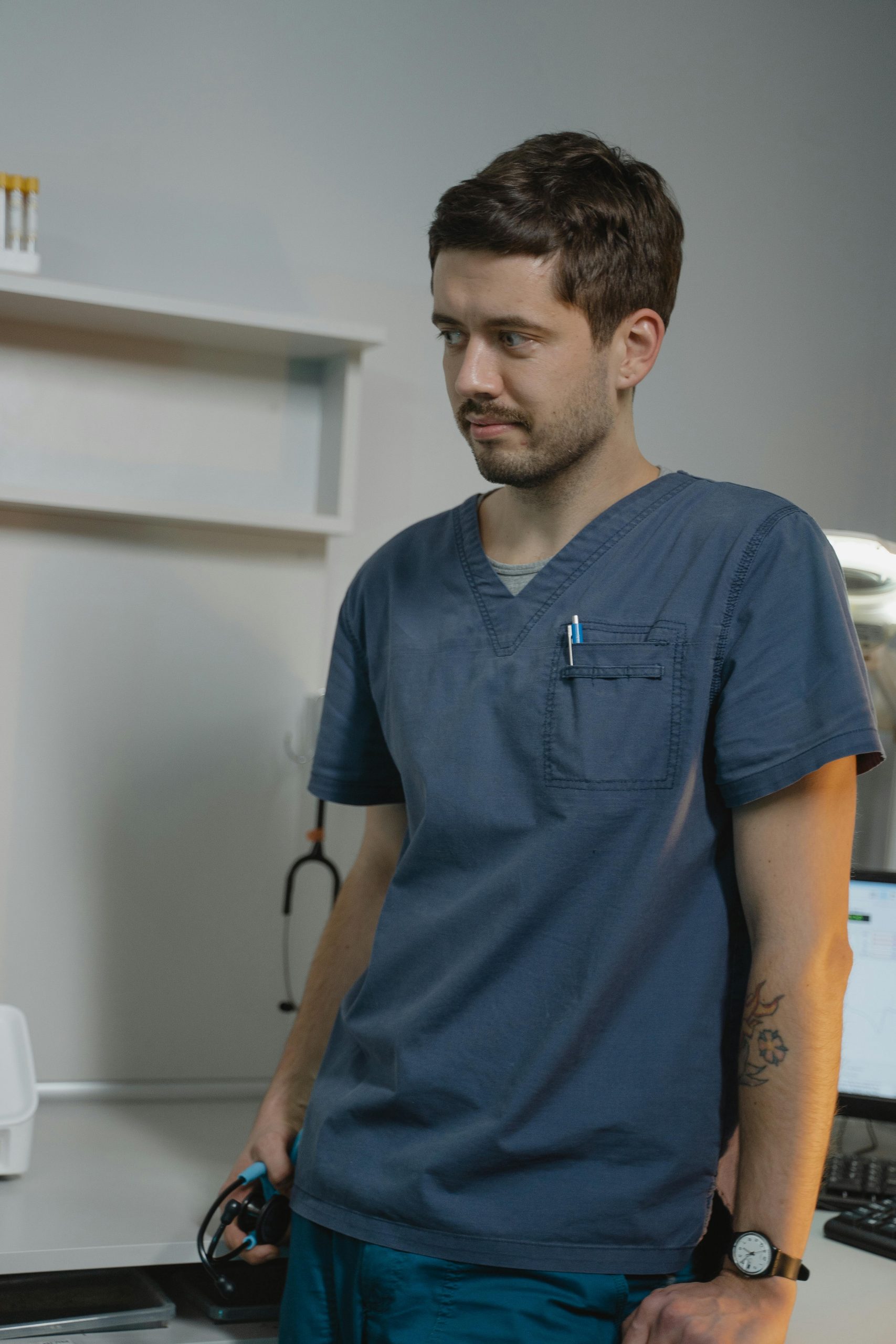 Healthcare professional standing in a modern medical clinic wearing scrubs and holding a stethoscope, representing healthcare providers seeking doctor loans, a medical clinic business loan, hospital capital expenditure solutions, buy a medical practice financing, and optometry practice loans to expand facilities, acquire practices, purchase equipment, and support long-term growth.