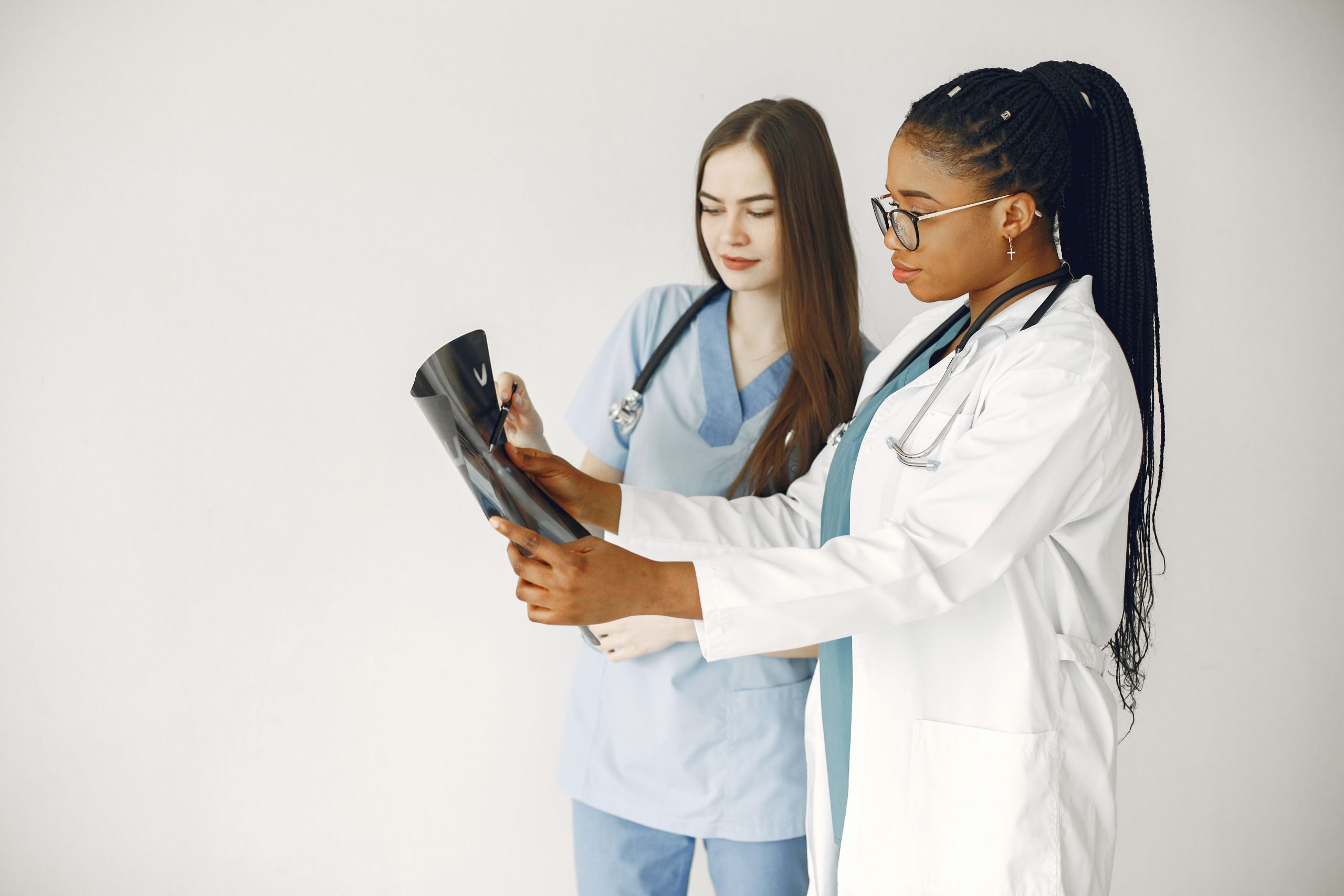 Two healthcare professionals reviewing diagnostic imaging while discussing medical claims financing, medical practice acquisition financing, healthcare business expansion loans, healthcare acquisition loans, and medical practice purchase loans to support clinic growth, practice ownership transitions, working capital needs, and healthcare business development.