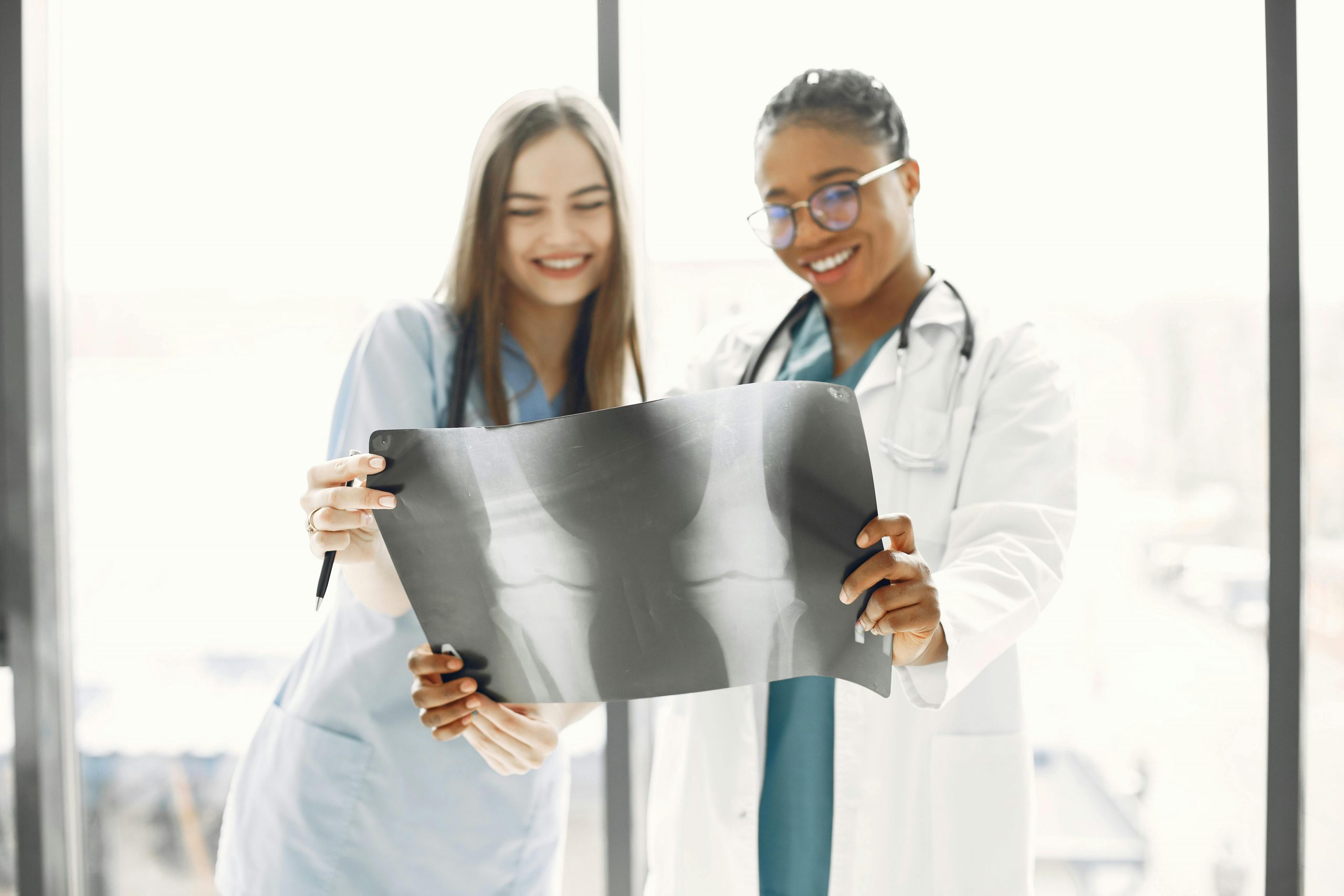 Two healthcare professionals reviewing a diagnostic X-ray image in a modern medical setting, representing hospital financing, healthcare technology loans, specialty clinic loans, medical facility modernization loans, and healthcare growth financing solutions that support advanced equipment, facility upgrades, and healthcare expansion.