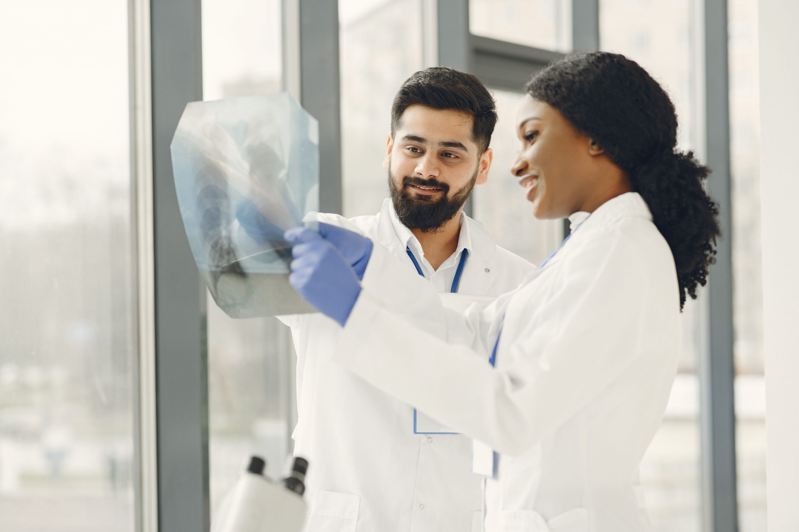 Two healthcare professionals reviewing diagnostic imaging while discussing practice growth strategies involving telehealth expansion funding, healthcare commercial mortgage solutions, practice transition financing, efforts to compare physician loans, and medical office purchase loans for expanding patient services, acquiring facilities, and modernizing healthcare operations.